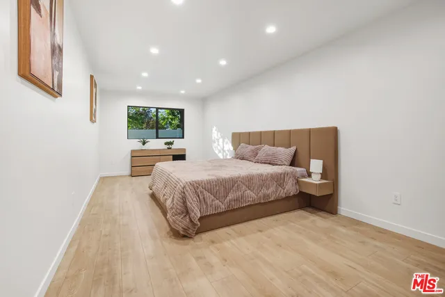 a spacious bedroom with a bed and a large window