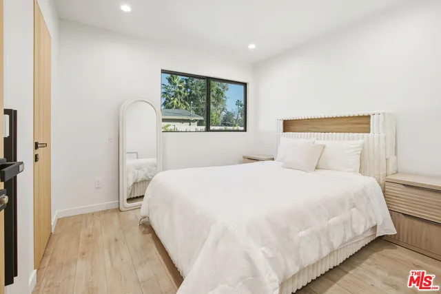 a large bed sitting in a bedroom next to a window