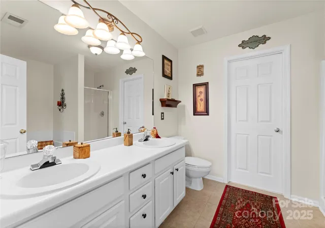 a bathroom with a double vanity sink mirror and toilet