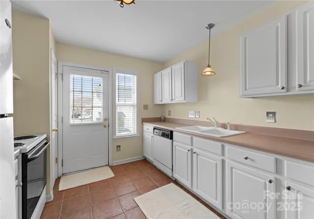 a kitchen with a sink window and cabinets
