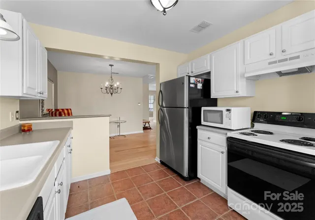 a kitchen with a refrigerator a stove a sink and cabinets