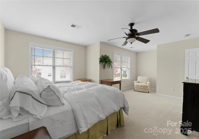 a spacious bedroom with a bed and a flat screen tv