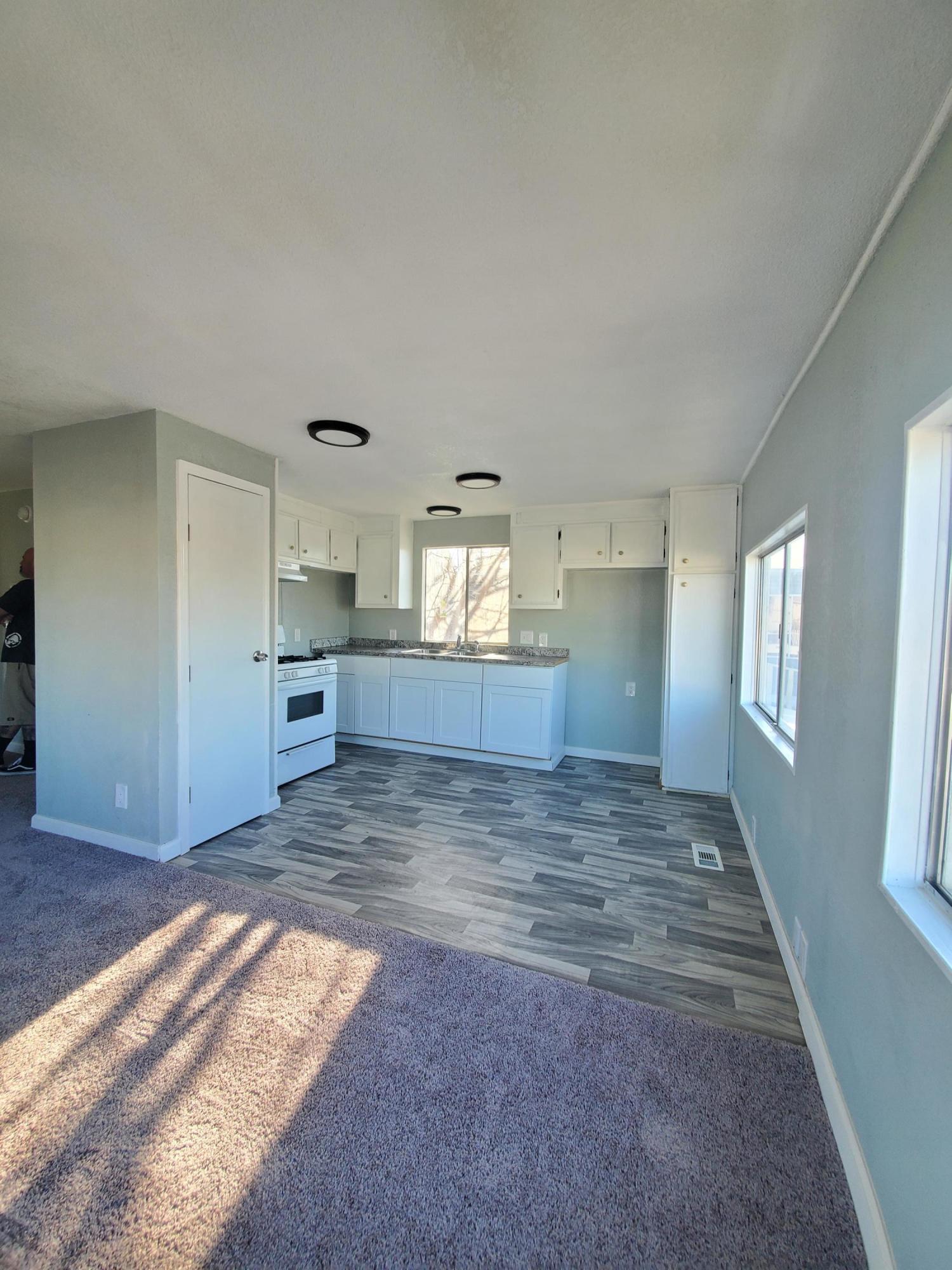 9630 Highway 41 Lemoore, CA 93245 - Photo 4 of 10 a view of kitchen and empty room with wooden floor