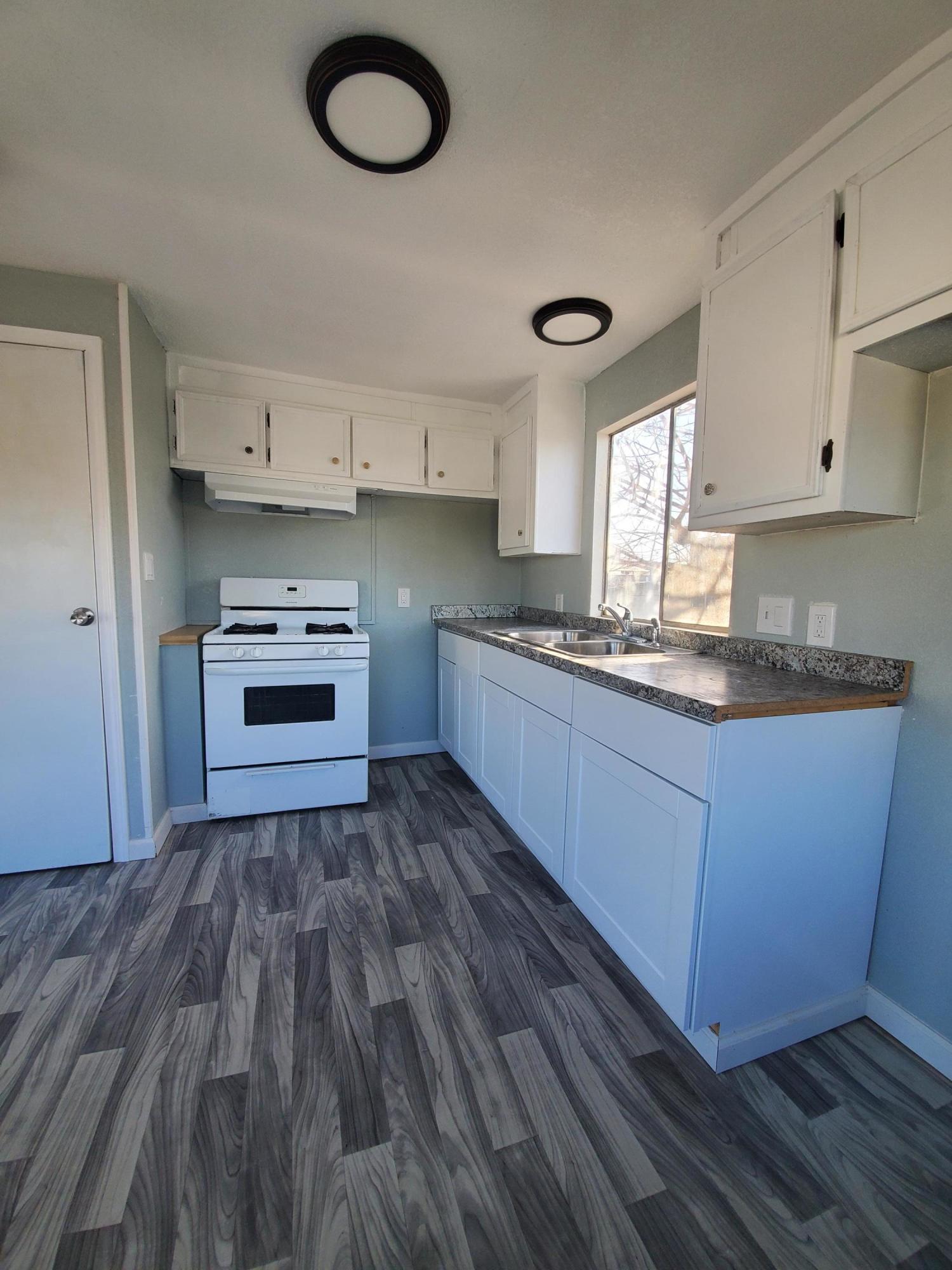 9630 Highway 41 Lemoore, CA 93245 - Photo 5 of 10 a kitchen with kitchen island granite countertop wooden cabinets and a sink