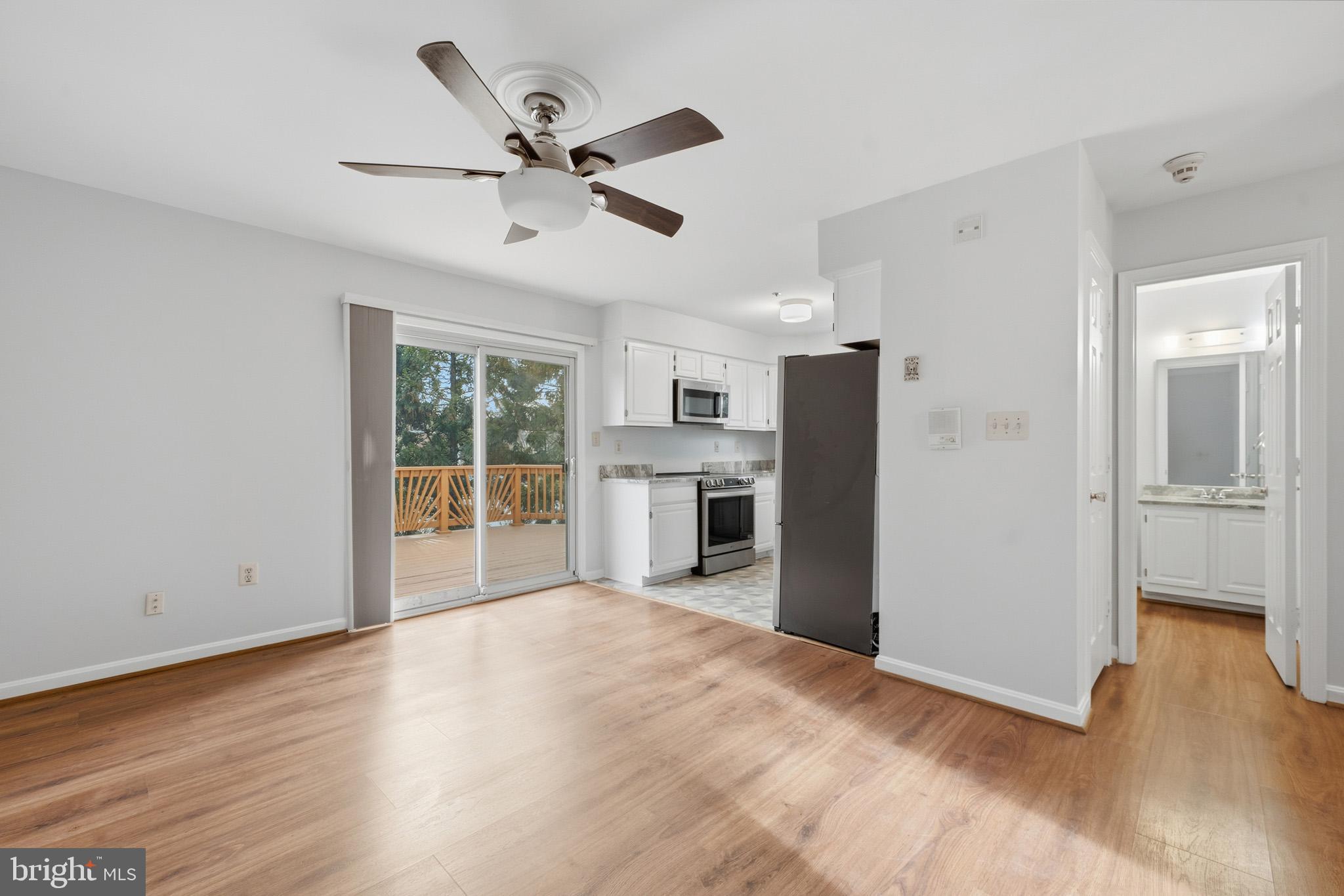 9146 Hardesty Drive Clinton, MD 20735 - Photo 21 of 47 a view of a big room with wooden floor a ceiling fan and windows