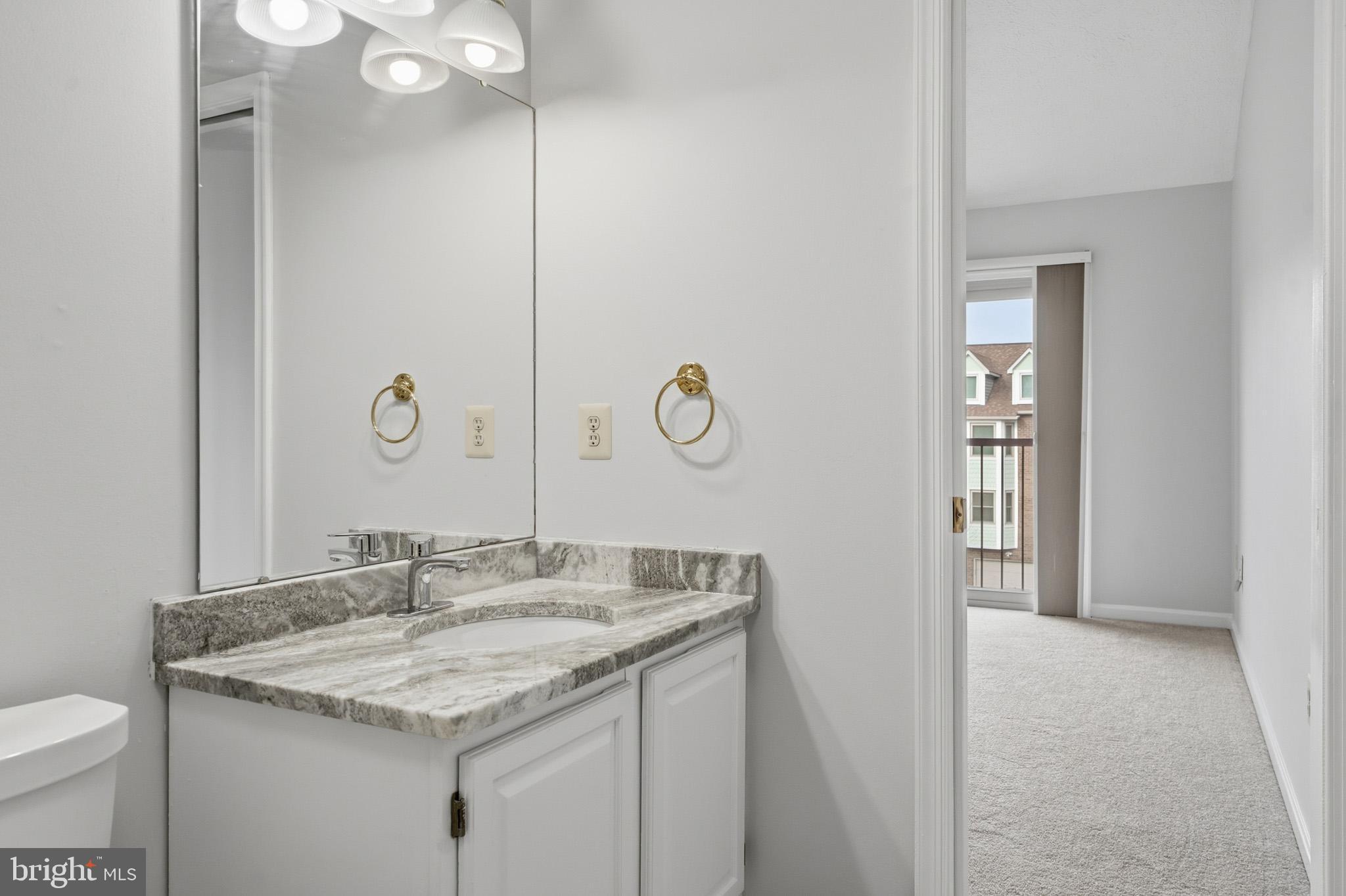 9146 Hardesty Drive Clinton, MD 20735 - Photo 35 of 47 a bathroom with a granite countertop sink a toilet and mirror