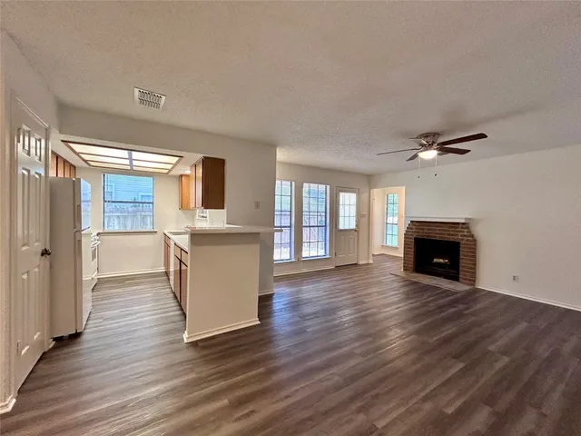 a view of a livingroom with wooden floor and a fireplace