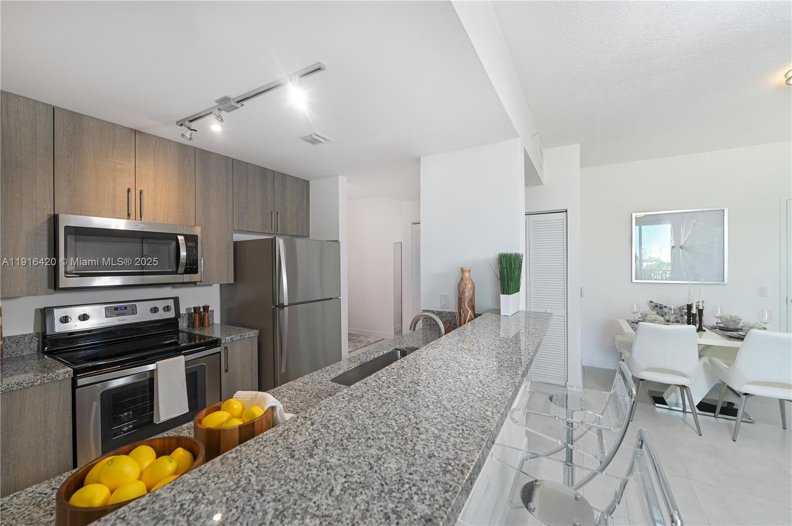 514 Southwest 22nd Avenue, Unit 204 Miami, FL 33135 - Photo 6 of 22 a kitchen with stainless steel appliances granite countertop a stove refrigerator and a sink