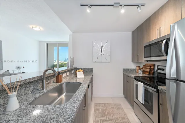 a kitchen with stainless steel appliances granite countertop a sink stove and refrigerator