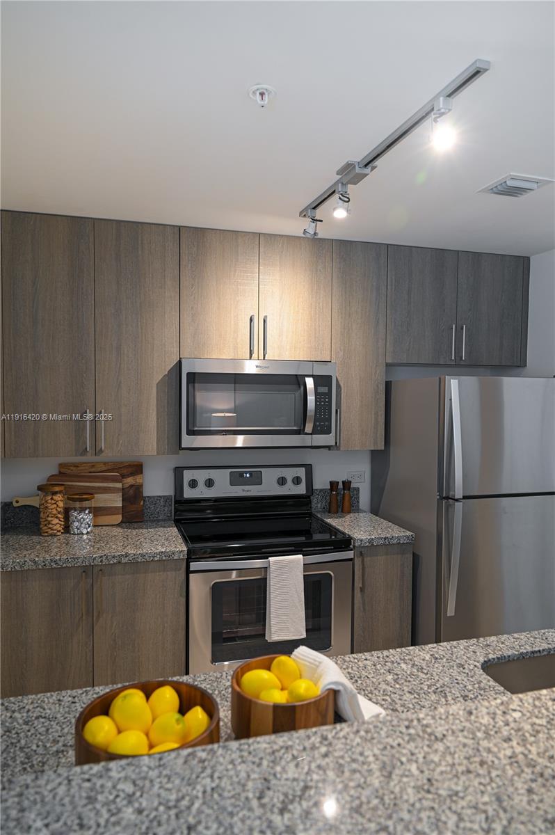 514 Southwest 22nd Avenue, Unit 204 Miami, FL 33135 - Photo 9 of 22 a kitchen with stainless steel appliances granite countertop a sink a stove a refrigerator a washer and dryer