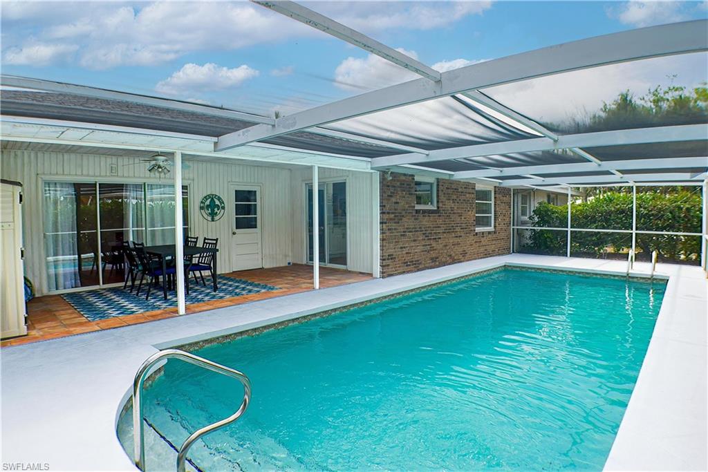 1056 Cardinal Street Naples, FL 34104 - Photo 1 of 32 View of swimming pool featuring a patio and a screened-in lanai