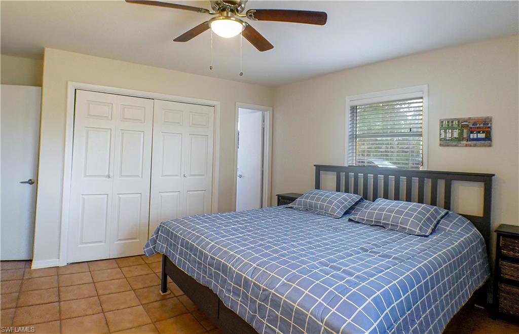 1056 Cardinal Street Naples, FL 34104 - Photo 16 of 32 Tiled bedroom featuring ceiling fan and a closet