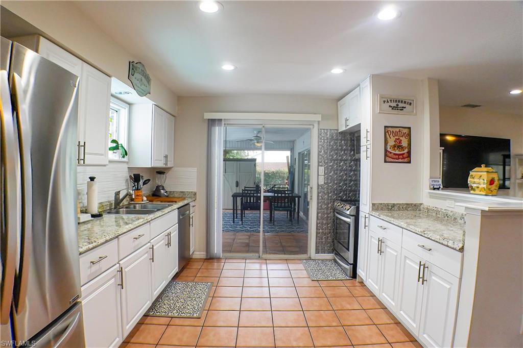 1056 Cardinal Street Naples, FL 34104 - Photo 6 of 32 Kitchen with plenty of natural light, white cabinets, tile flooring, and appliances with stainless steel finishes