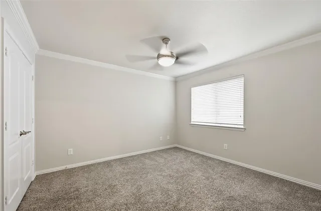 an empty room with a window and a ceiling fan