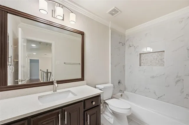 a bathroom with a sink a toilet a mirror and shower