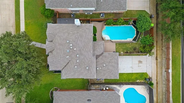 an aerial view of a house with a swimming pool garden and patio