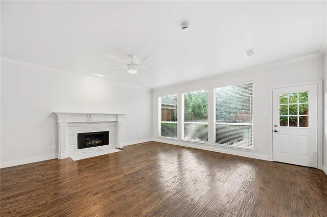 a view of empty room with wooden floor and fireplace
