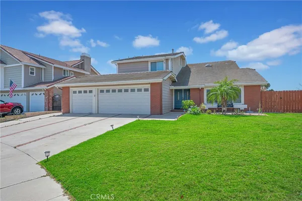 a front view of a house with a garden and yard