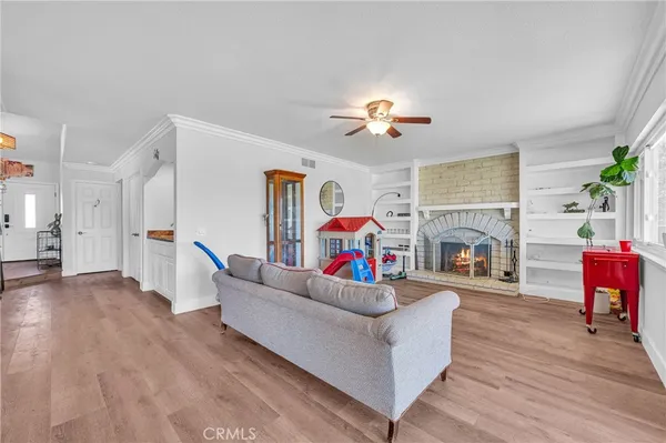 a living room with furniture kitchen view and a wooden floor