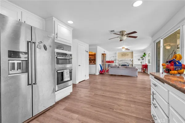 a kitchen with stainless steel appliances kitchen island granite countertop a refrigerator and a stove top oven