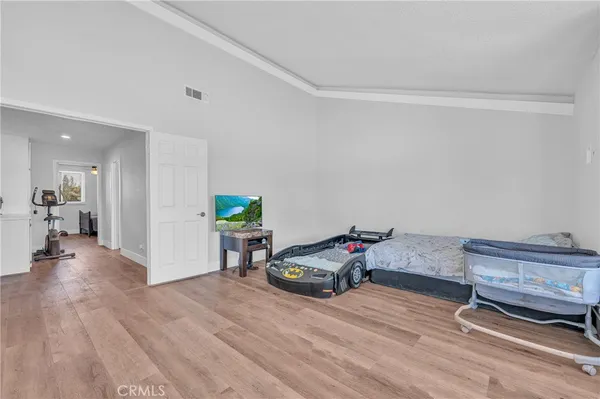a spacious bedroom with a bed and wooden floor