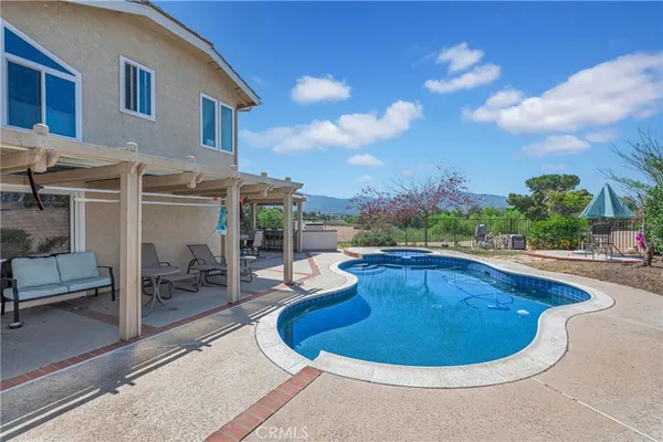 a view of a house with swimming pool and sitting area
