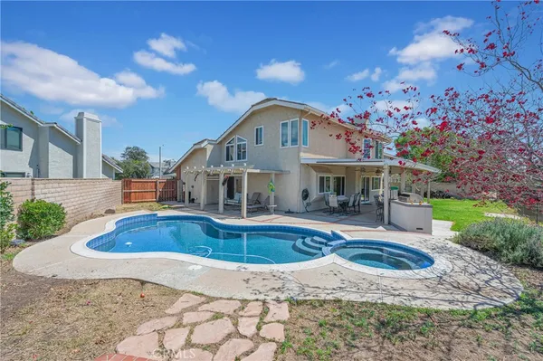 an aerial view of a house with swimming pool and outdoor seating