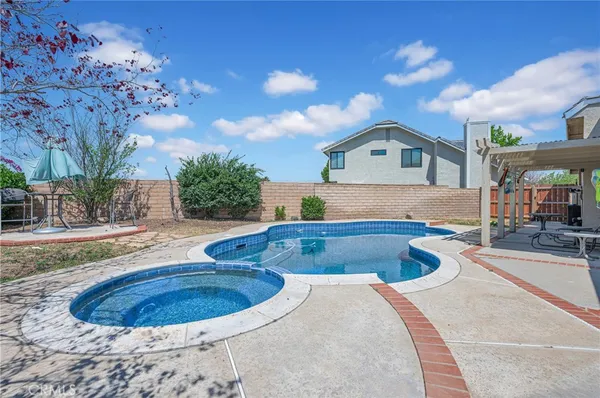 an aerial view of a house with swimming pool and outdoor seating