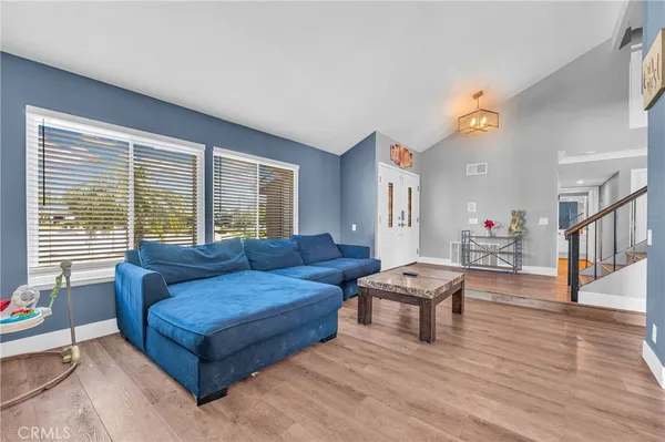a living room with furniture a flat screen tv and a window