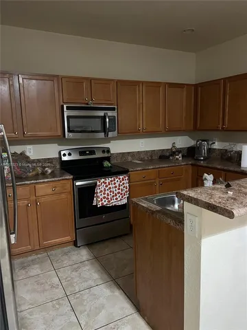 a kitchen with a sink a stove and cabinets
