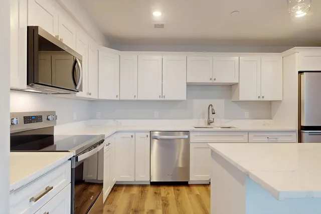a kitchen with stainless steel appliances granite countertop a sink and a microwave