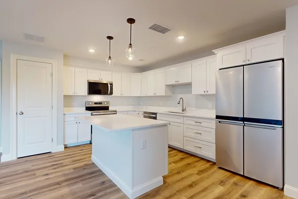 a kitchen with white cabinets and white appliances