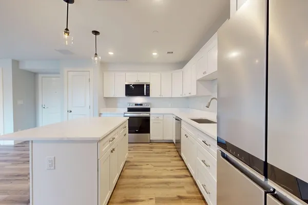 a kitchen with white cabinets appliances and sink