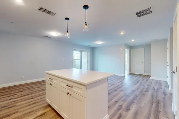 a view of kitchen with wooden floor and electronic appliances