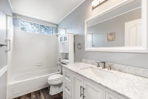 a bathroom with a granite countertop sink toilet and shower