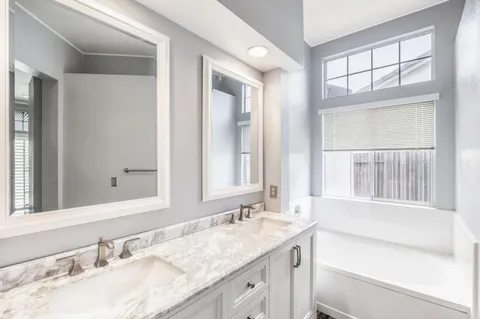 a bathroom with a granite countertop sink and a large mirror