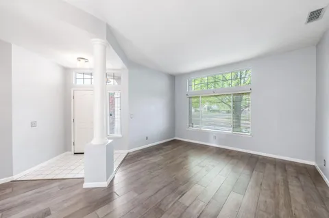 an empty room with wooden floor and windows