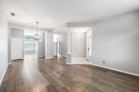 a view of a kitchen with wooden floor and a refrigerator
