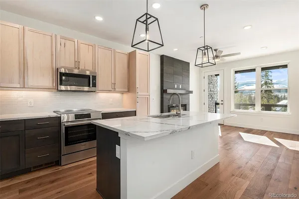 a kitchen with stainless steel appliances granite countertop stove a microwave oven a sink and dishwasher with wooden floor