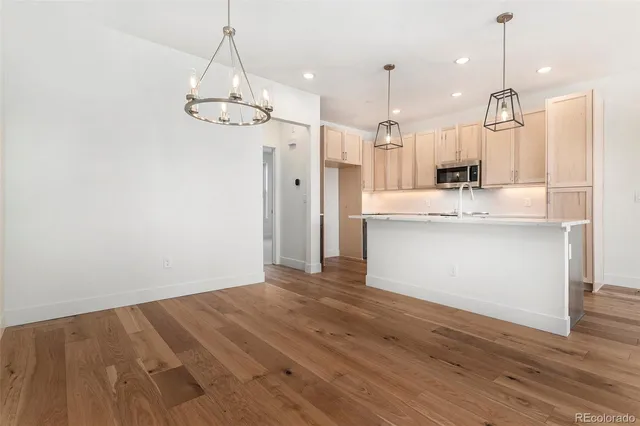 a kitchen with a sink a counter space and wooden floor