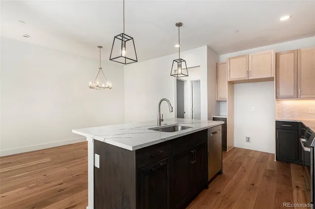 a kitchen with stainless steel appliances granite countertop a sink a refrigerator and microwave