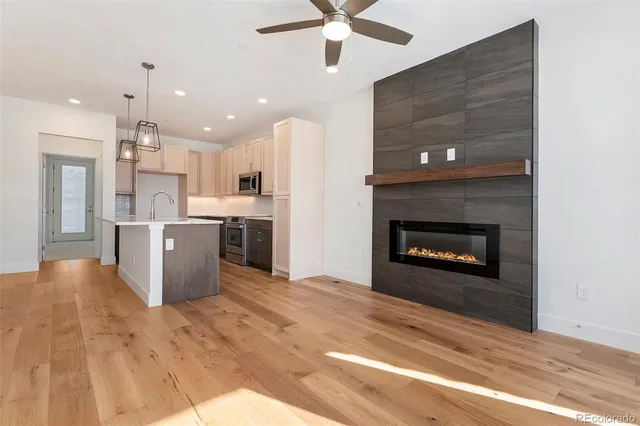 a open kitchen view with fireplace a stove and a chandelier