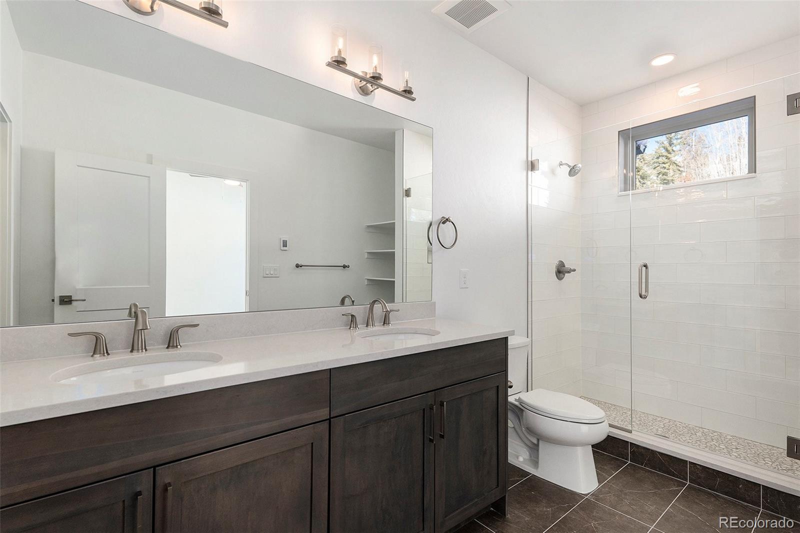 86 High Grove Loop Fraser, CO 80442 - Photo 10 of 20 a bathroom with a double vanity sink toilet mirror and shower