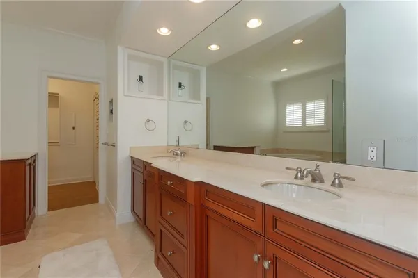 a spacious bathroom with a granite countertop sink a mirror and a shower