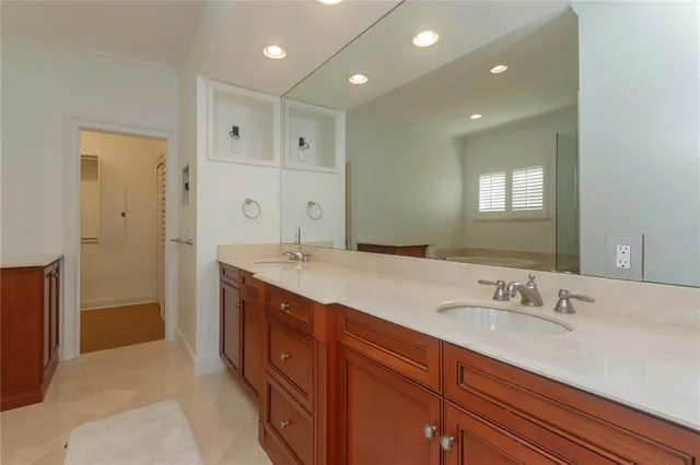 a spacious bathroom with a granite countertop sink a mirror and a shower