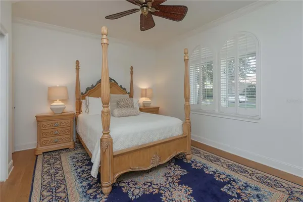 a bedroom with a bed wooden floor and a rug