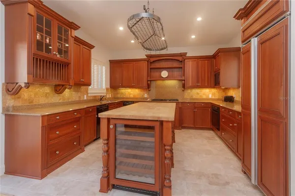 a kitchen with kitchen island granite countertop a sink cabinets and window
