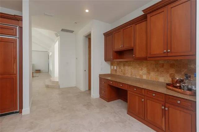 a kitchen with stainless steel appliances granite countertop wooden cabinets and a refrigerator