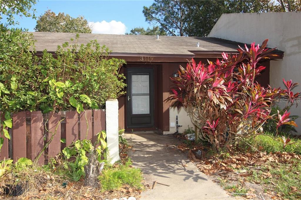 a front view of a house with a tree