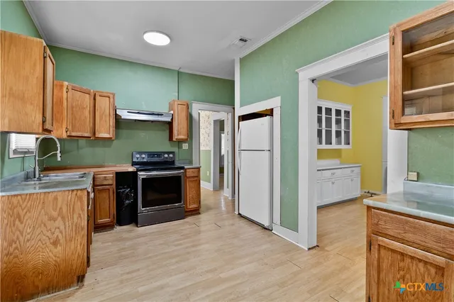 a kitchen with a refrigerator and a stove top oven